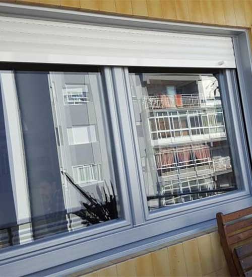 Fotografía de una ventana nueva con persiana.